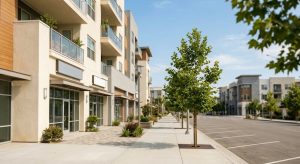 Newer mixed-use downtown streetscape with wide sidewalks and young street trees in a Southern California transit district
