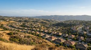 Yorba Linda foothill rooftops in late-afternoon summer light, editorial real-estate photograph.
