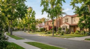 Representative Orange, California suburban homes on a tree-lined street, early summer, quarterly market portrait.